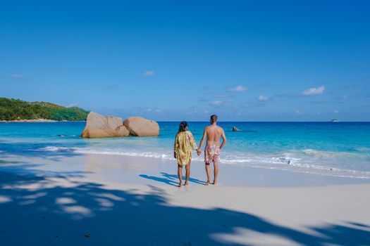 Praslin Seychelles tropical island with withe beaches and palm trees, couple men and women mid age on vacation at the Seychelles visiting the tropical beach of Anse Lazio Praslin Seychelles
