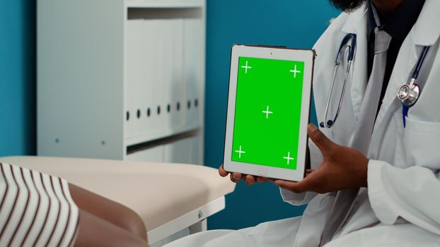 General practitioner holding digital tablet with greenscreen