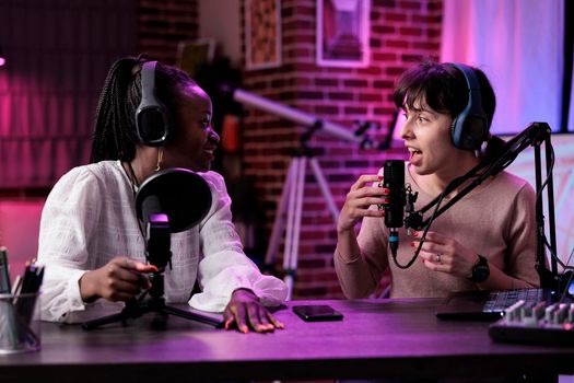 Multiethnic team of women hosting podcast conversation in studio
