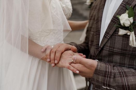 Wedding couple touches each others by hands. Love and tenderness. Advert for wedding agency.