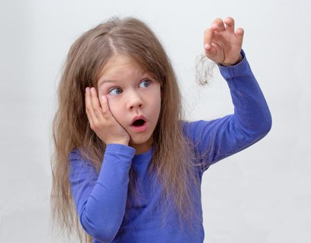 Scared child with holding piece of hair