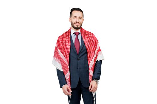 Handsome arabic businessman in suit and shemagh smiles on white blank background in studio. Business portrait of successful man.