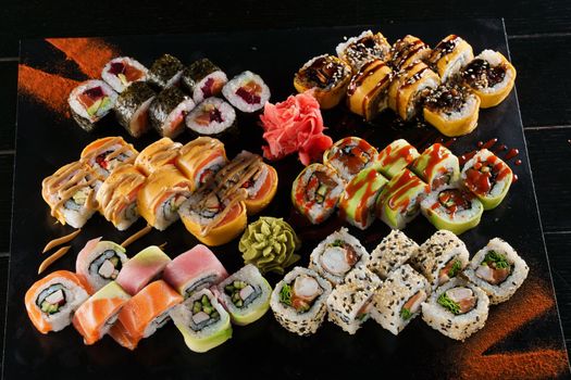 Sushi set on black background. Traditional Japanese seafood. Delicious roll. Advert for food delivery service.