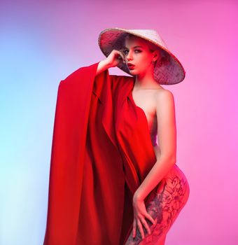 the sexy nude girl in an asian triangular hat in a red cape