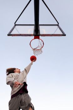 man playing in a basketball hoop seen from below