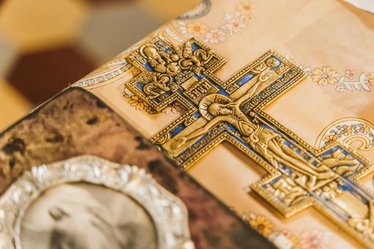 Orthodox cross and holy book with picture of Jesus Christ on the table in church. Orthodox faith. Equipment for praying. Pray for people life. Pray to god.