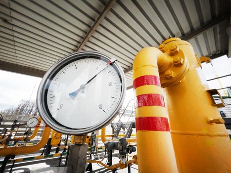 Yellow gas pipeline with a large pressure gauge for measuring gas pressure