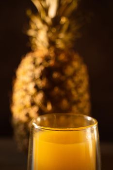 Pineapple fruit and juice in double glass cup. Tropical fruit . Pouring yellow tropical juice into glass