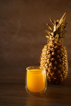 Pineapple fruit and juice in double glass cup. Tropical fruit . Pouring yellow tropical juice into glass
