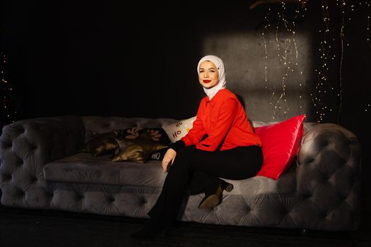 Muslim woman near christmas lights and decoration in studio. Professional muslim model posing at the new year eve
