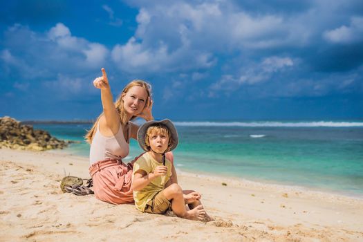 Mom and son travelers on amazing Melasti Beach with turquoise water, Bali Island Indonesia. Traveling with kids concept