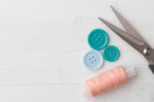 Colorful sewing accessories on white wooden table