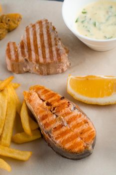 Barbecue seafood kebab with grilled mussels, tuna, salmon on a wooden skewer with white sauce and lemon