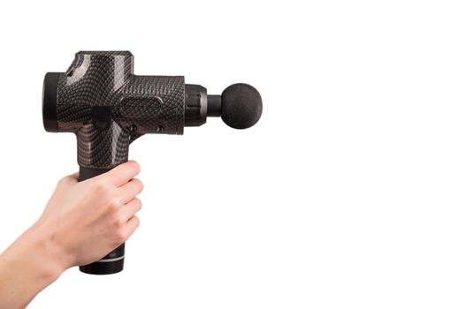 Close-up of a female hand with a portable massager gun on a white background.