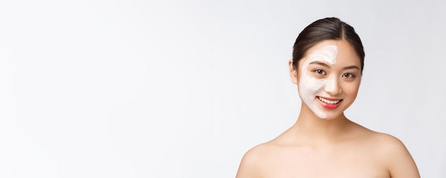 Charming pleasant woman applying cream on half face