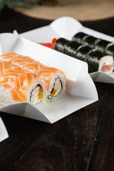 Philadelphia roll on the food delivery plate. Roll with salmon, shrimp and mango.