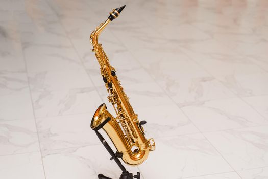 Saxophone musician instrument on stand on white background. Sax musical instrument for play jazz.