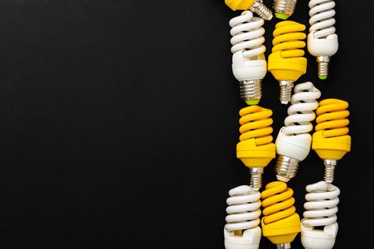White and yellow light bulbs on black background