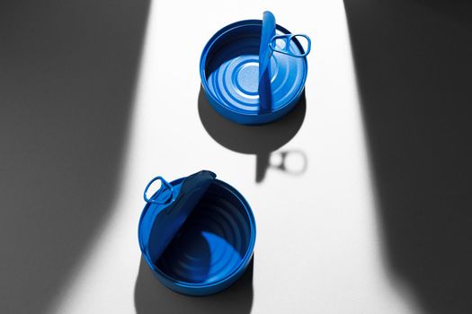 Painted blue opened tin can with ring on white background