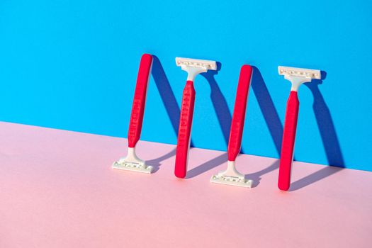 Disposable razor on blue and pink background