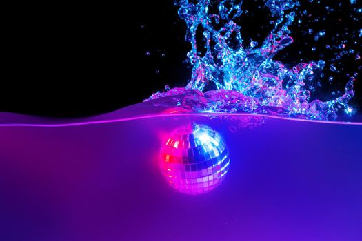 Disco ball falling into the water with a splash against black backgorund, neon light