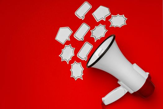 Electronic megaphone with speech bubble on red background