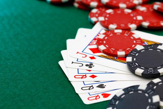 Playing cards and chips on green casino table background
