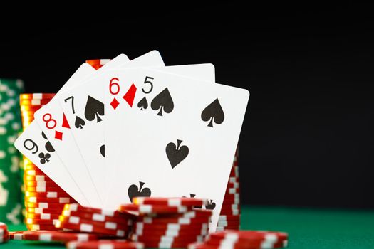 Red playing chips and cards on poker table