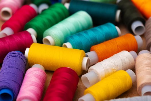 Many colored spools of threads as a background