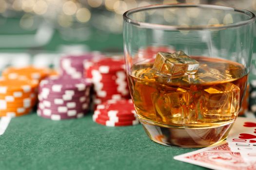 Cards, playing chips and alcohol in glass