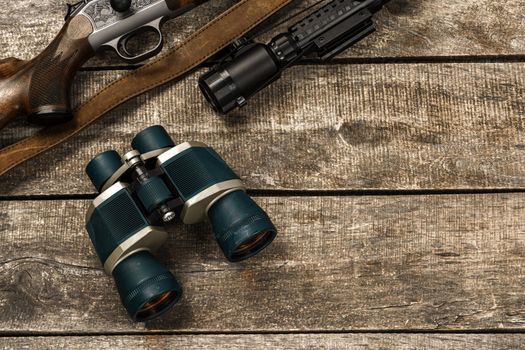 Hunting equipment binoculars on wooden background close up