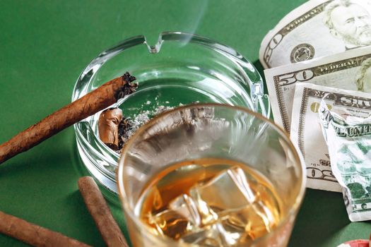 Cuban cigar and money on green background