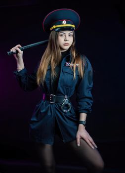 a woman in a Russian police uniform with a baton. English translation Police