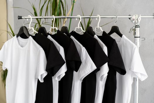 Row of black and white t-shirts hanging on rack