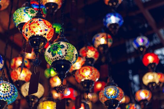 Middle Eastern lamps of different colors hanging in bazaar