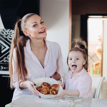 Happy mother and daughter showing baked curd fritter