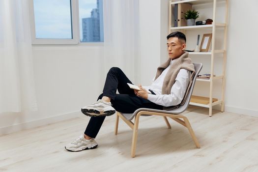 handsome man sweater on shoulders tablet internet interior