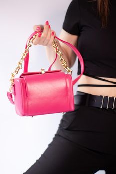 womans hand holding a pretty little pink handbag. Product photography. stylish handbag and purse for women.