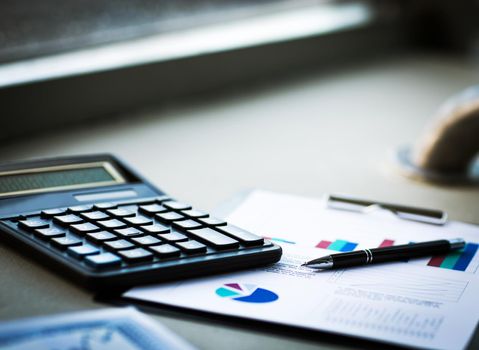 Calculator with documents on accounting in the workplace in the office