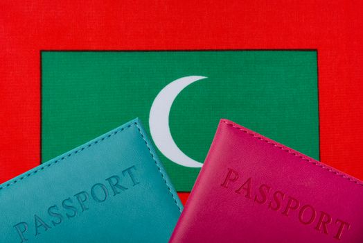 On the background of the flag of Maldives two passports.