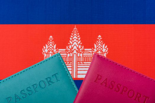 On the background of the flag of Cambodia and two passports.