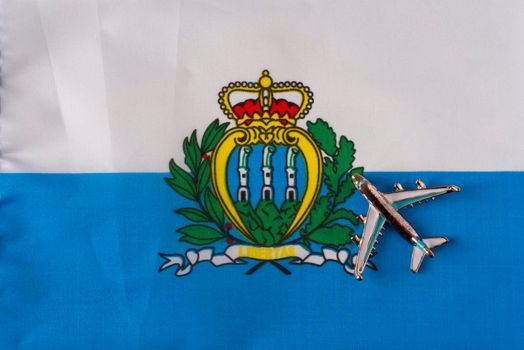 Airplane over San Marino flag travel concept.