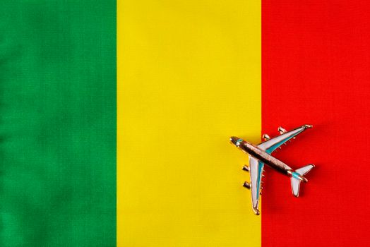 Plane over the flag of Mali travel concept.