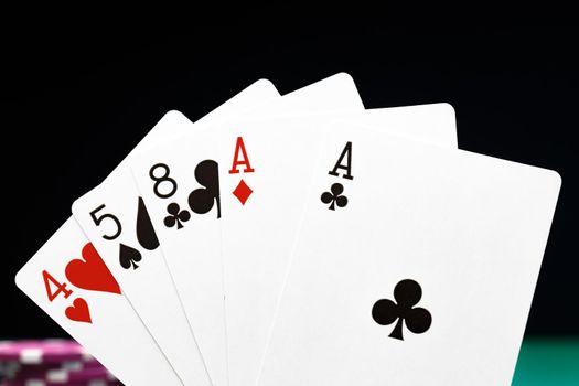 Poker chips and playing cards on black background