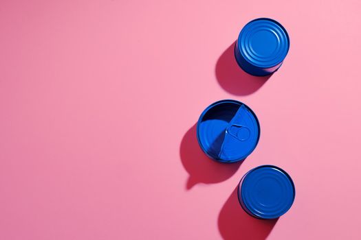 Aesthetic concept with blue painted tin can on pink background