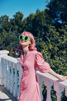 glamorous woman in pink dress green glasses summer fashion. High quality photo