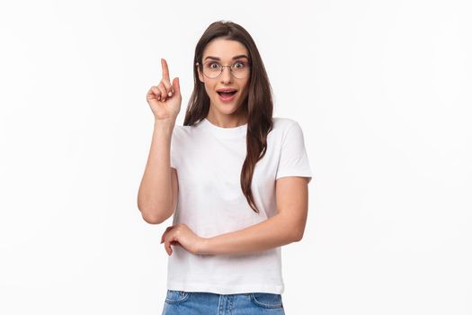 Waist-up portrait of excited, creative and smart talented pretty woman in glasses suggesting great idea, raise finger up eureka gesture, smiling enthusiastic, propose plan, think-up solution