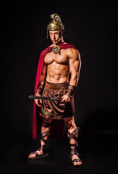 Young muscular man posing in roman gladiator costume