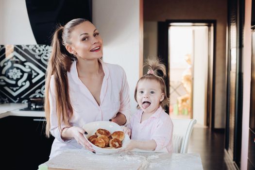 Happy mother and daughter showing baked curd fritter