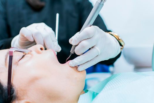Close up o patient checked by dentist, dentist performing root canal treatment on patient, dentist performing dental checkup
